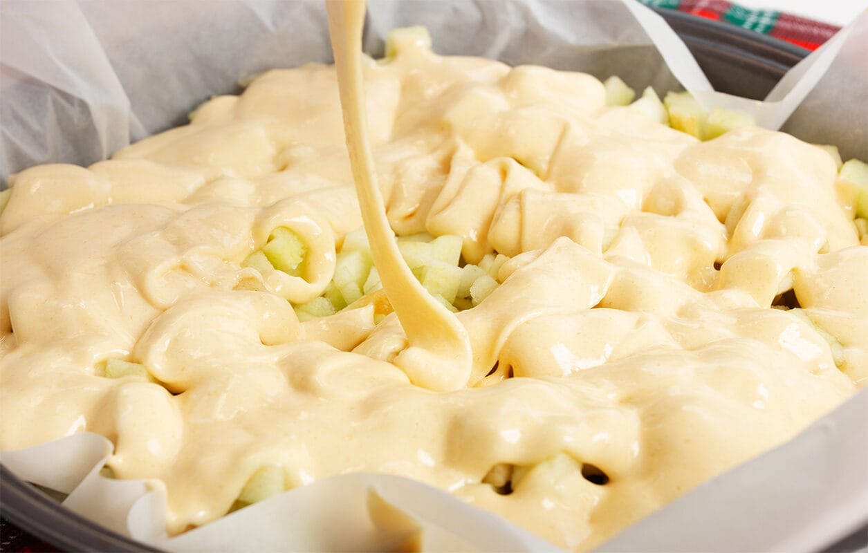 making-a-cake-girl-pours-green-apples-into-cooked-dough-2