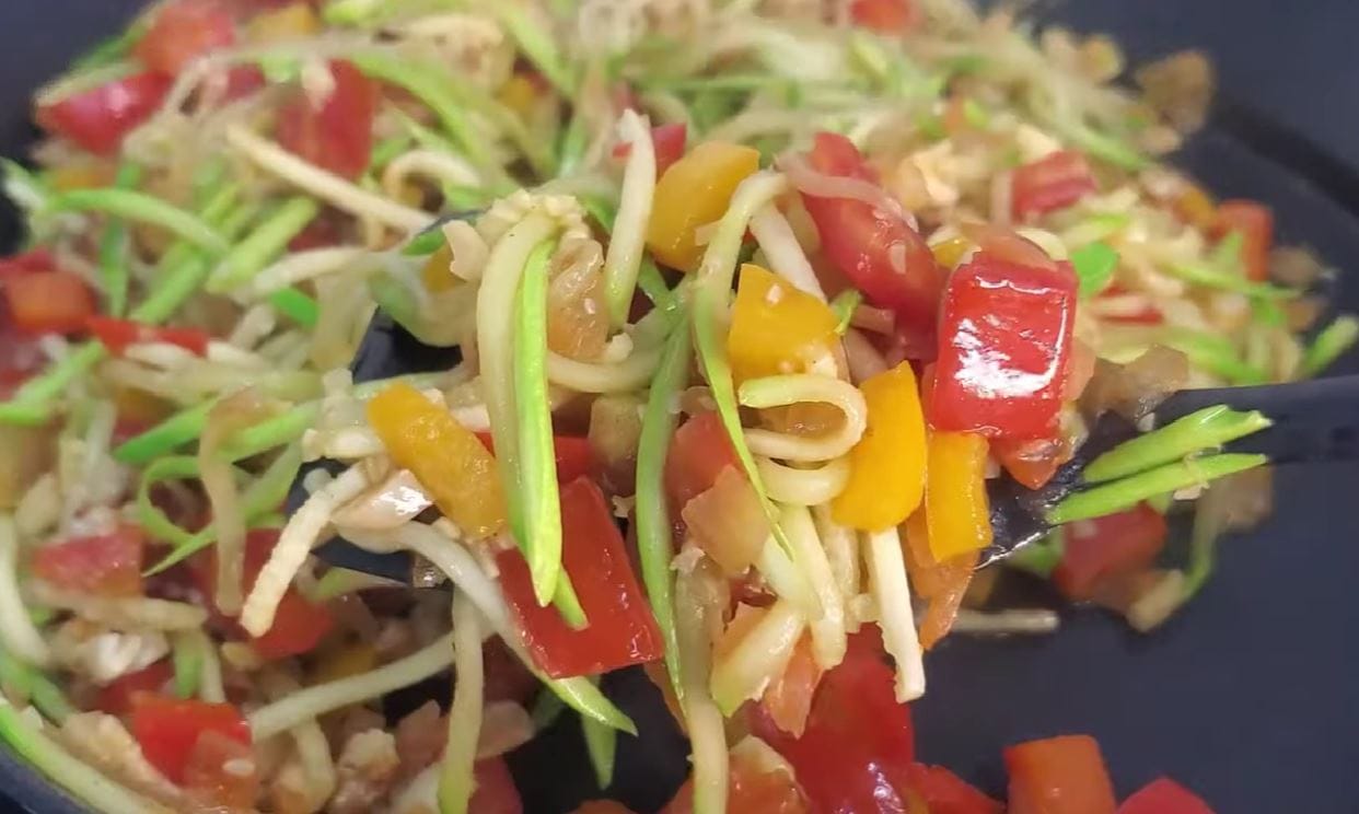 Zucchine, peperoni, pomodori e noci in padella